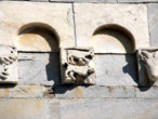 Stazzema (Lucca), chiesa di S. Maria Assunta, facciata: teoria di archetti pensili con mensole figurate, particolare. Stazzema (Lucca), chiesa di S. Maria Assunta, facciata: teoria di archetti pensili con mensole figurate, particolare.